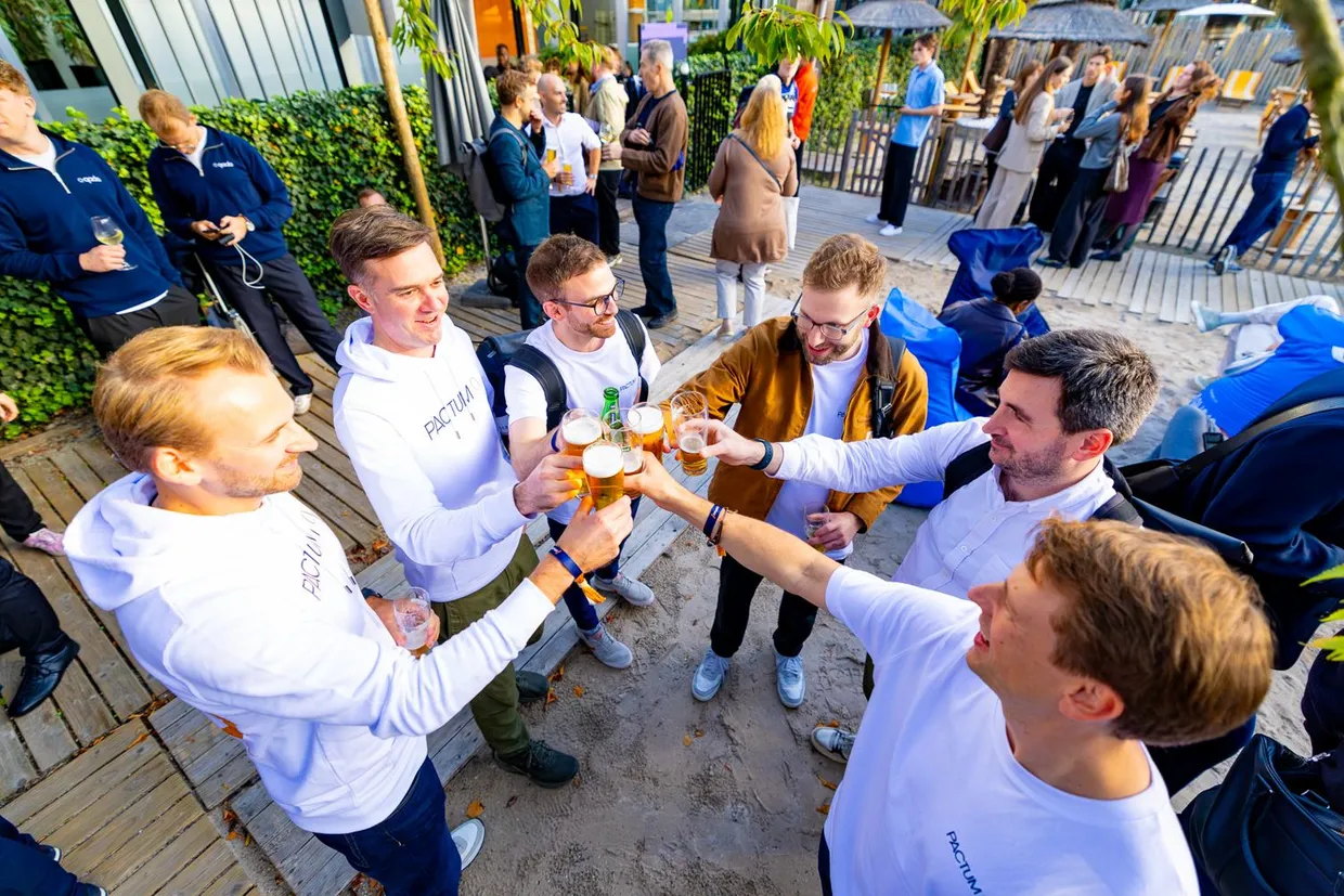 The Pactum team raising a toast with attendees at the end of day two