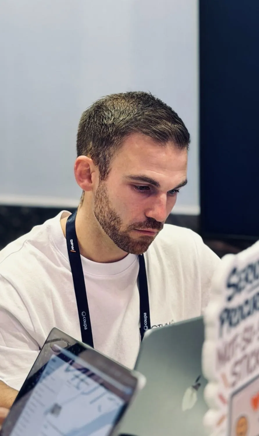 A Pactum team member working on a laptop at the stand