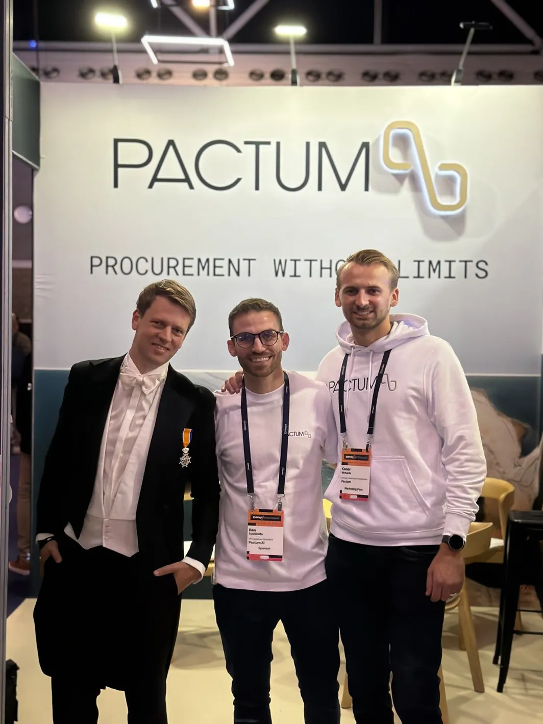 Three members of the Pactum team at the stand under the Procurement without limits sign